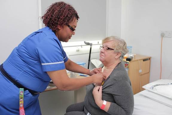 a member of staff is positioning the SensiumVitals patch on patients chest