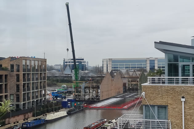 A crane dismantling warehouses on Commerce Road 