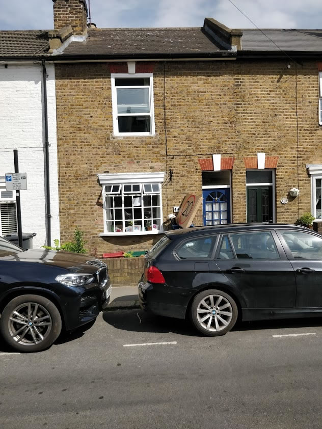 A car parked in front of a brick building  Description automatically generated